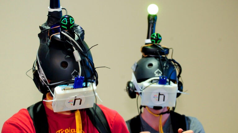 Two students wearing a virtual reality headset.