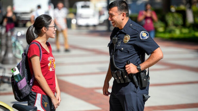 Student talking with police officer on campus