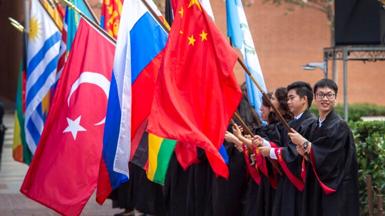 Students holding international flags in a line