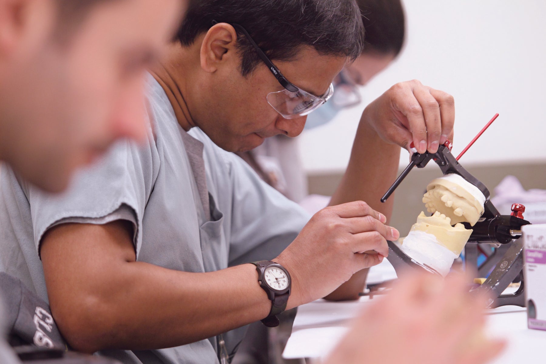 Dentist working on a set of dentures for a patient.