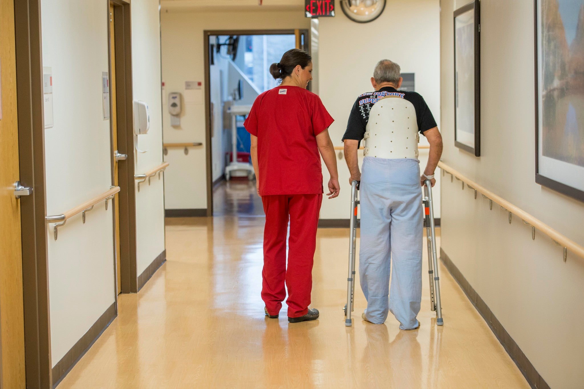 A nurse next to an elderly man with a walker