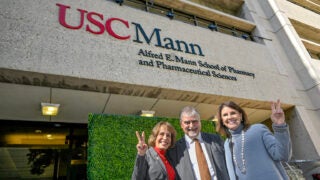 USC President Carol L. Folt, Dean Vassilios Papadopoulos and USC Trustee Chair Suzanne Nora Johnson, from left, pause in front of the building sporting the school’s new name.