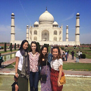 Four USC Marshall School of Business students stand in front of the Taj Mahal.