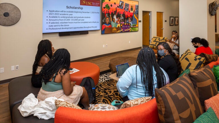 A group of five students sitting on couches in the Center for Black Cultural and Student Affairs lounge.