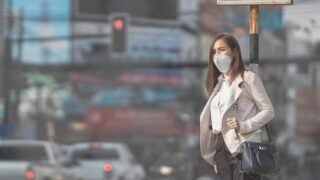 Woman waiting to cross traffic.