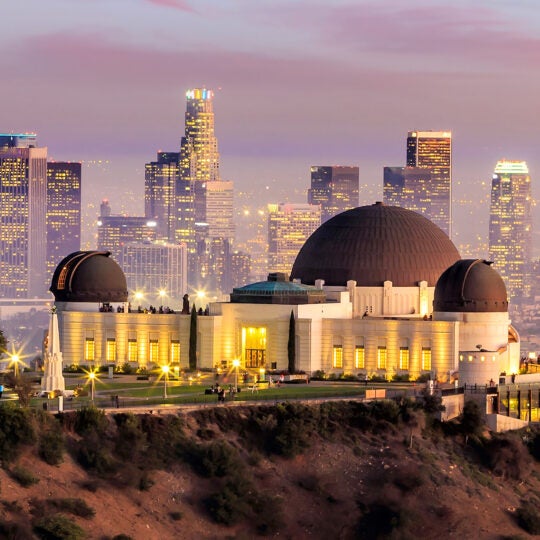 The Griffith Observatory and Los Angeles city skyline at twilight.