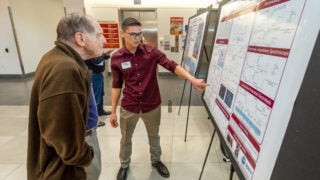 Student presenting his poster at Michelson Center's research facility