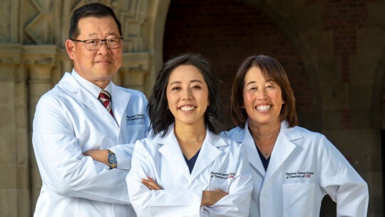 Senior Nicole Kawakami, center, will be graduating with her DDS degree from USC like her mother Ruth Kawakami, right and her Uncle Kent Ochiai, left, did. Three generations of Herman Ostrow School of Dentistry of USC graduates pose for a photograph, Feb. 11, 2022. (Photo/Gus Ruelas)