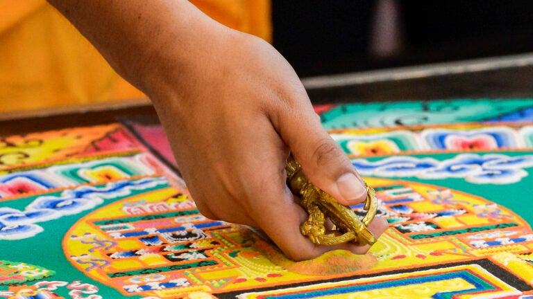 Tibetan Monks work on a sacred sand mandala at the USC Asian Pacific Museum.