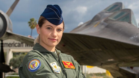 Graduating USAF ROTC cadet, Sarah Markosky poses for a photograph in front of the SR-71 Blackbird aircraft on display outside the California Science Center, March 8, 2021. (USC Photo/Gus Ruelas)