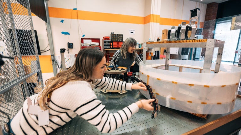 A student building a robot at the Space Engineering Research Center.