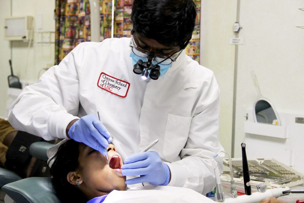 Dentistry professor working on a cleaning a patient's mouth