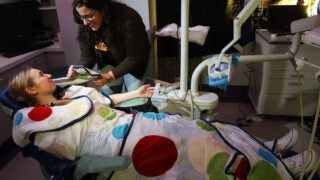 Medical Professional helping a young girl during a teeth cleaning