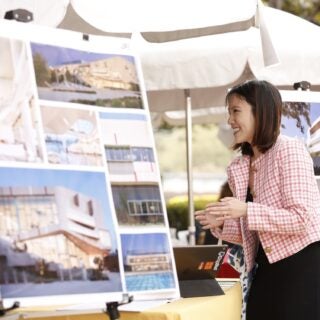 A USC architecture student smiles while viewing several architectural renderings during a job fair