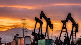 Oil pumps with shipping containers with local L.A. mountains in the background