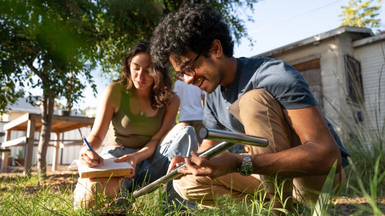 Two USC students study the soil