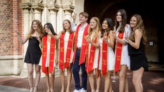 Eight USC students pose in front of Bovard