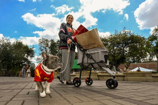 a person with a dog on campus wearing USC gear