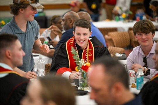 a graduate sitting with friends