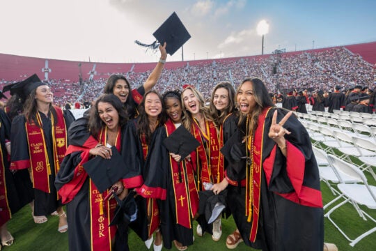 USC graduates hug and celebrate