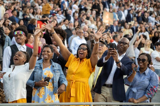 Family with hands in air celebrates USC graduates