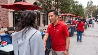 USC Interim President Kim shares a moment with a student while welcoming Trojans to USC Village. (USC Photo/Henry Kofman)