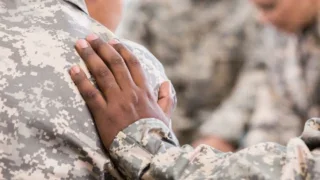 A military personnel touches another military personnel shoulder