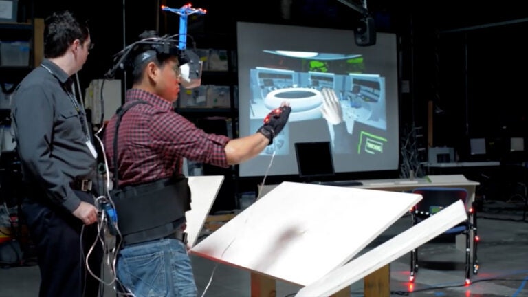 A male student using a glove tied to a computer simulation